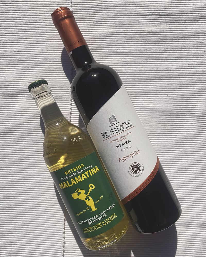 Eine Flasche Rotwein aus Nemea und eine Flasche Retsina auf dem Tisch